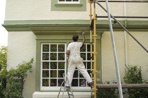 A house painter is painting the exterior of a house in Oklahoma City.