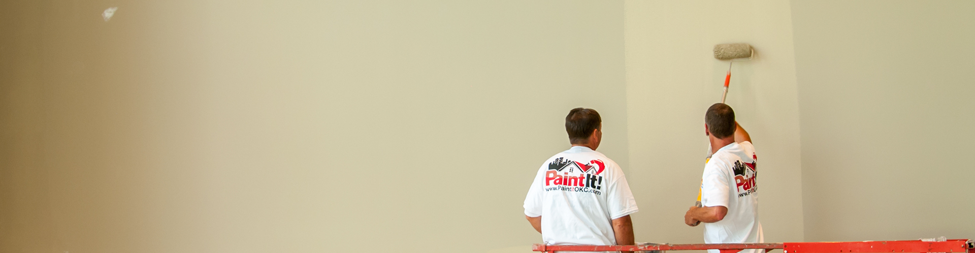 A picture of two Paint It OKC house painters working on an interior painting project.